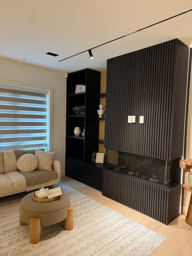 Living room with fluted fireplace feature and built-in shelving